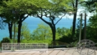 image of a Trex deck overlooking Lake Ontario. Deck has clear tempered glass railings with stainless steel posts