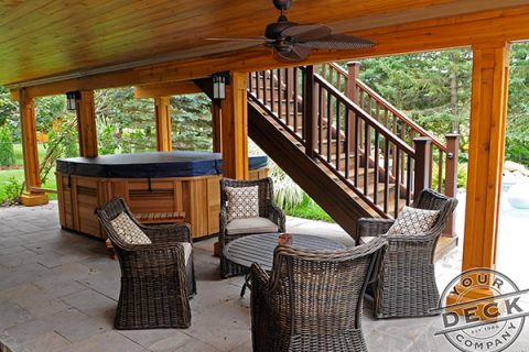 An image of a deck finished using Trex RainEscape with a Cedar ceiling and pillars