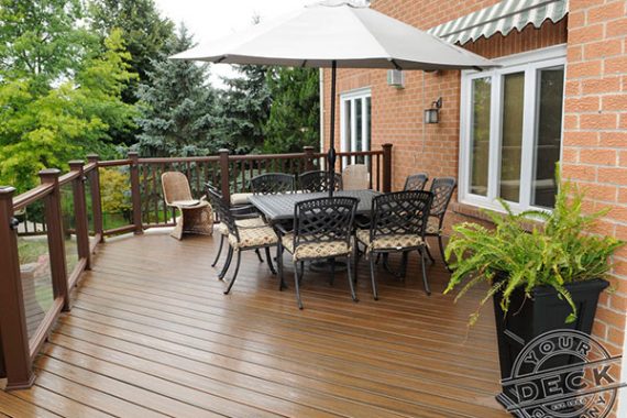 image of a finished trex deck using spiced rum decking and glass railings